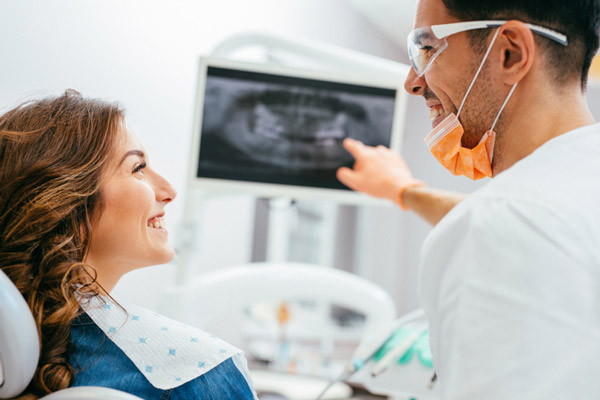 Image of a woman smiling with a dental professional, at St. Louis Prosthodontics.